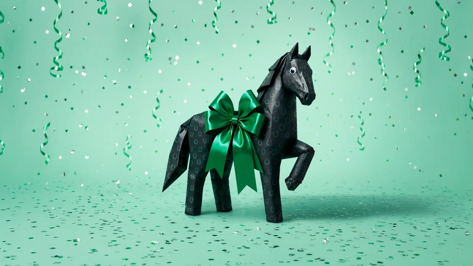 Lloyds Gift Horse: the black horse folded from wrapping paper with a green bow, in a shower of confetti